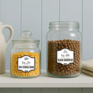 Glass jars with pantry labels for pulses – split Bengal gram (yellow lentils) and black chickpeas – featuring English and Urdu names.