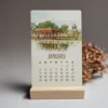 Nostalgic Lahore 2026 Mini Calendar Nostalgic Lahore 2026 Mini Calendar January card displayed on a wooden stand, featuring a watercolor painting of Shalimar Gardens.